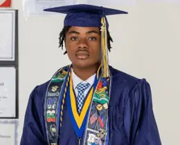 Pierre Damas Bel wearing his graduation cap and gown.